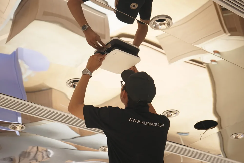 Technician mounting an access point on the store ceiling