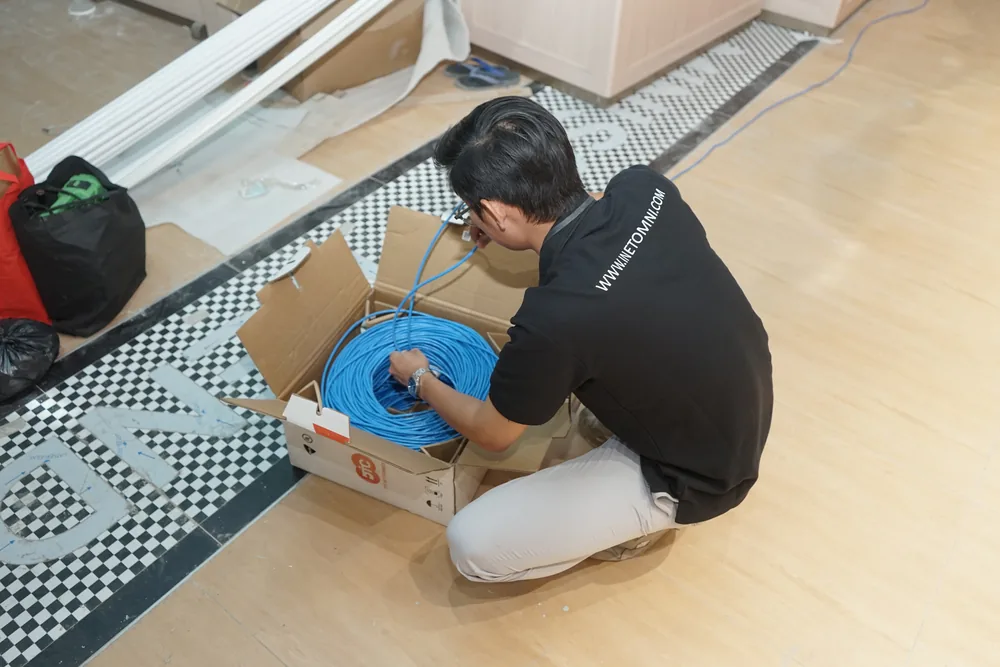 Technician pulling LAN cable towards the conduit run