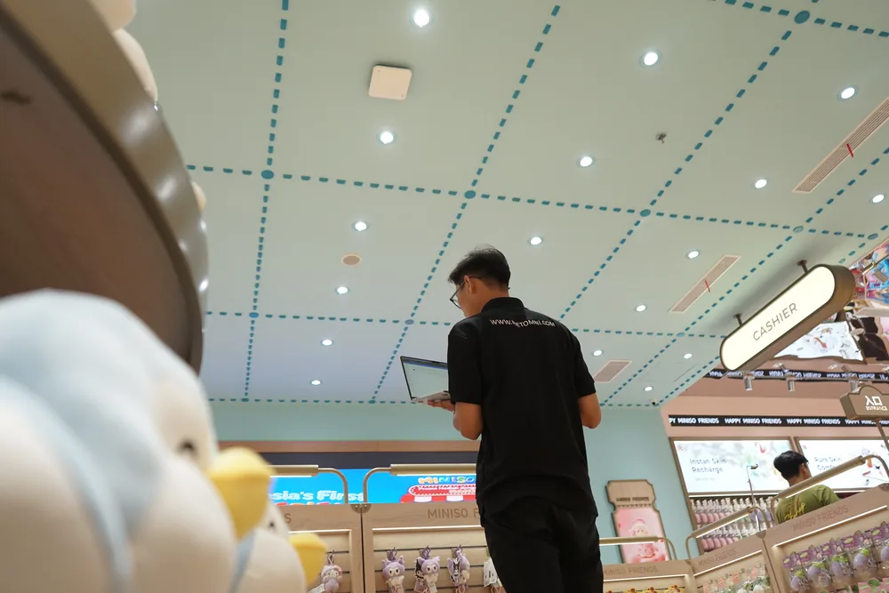Technician checking network devices with a laptop in the store