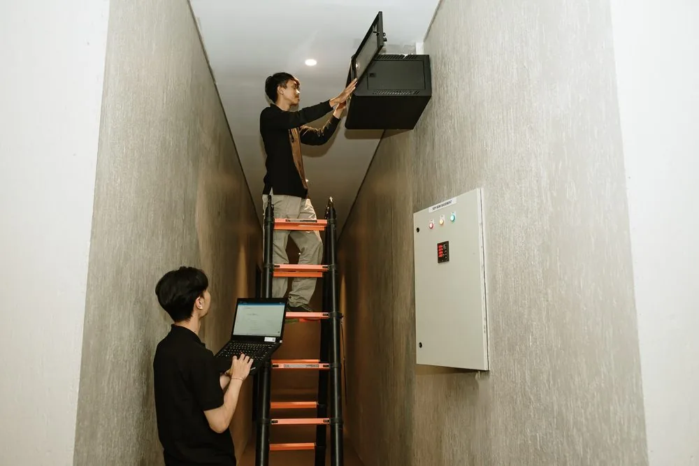 Technicians mounting network equipment on the wall